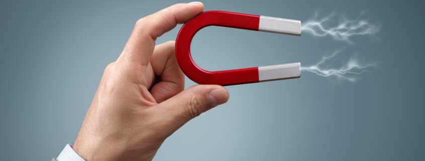 a hand holding a magnet demonstrating a magneting field which is used for adhesive debonding